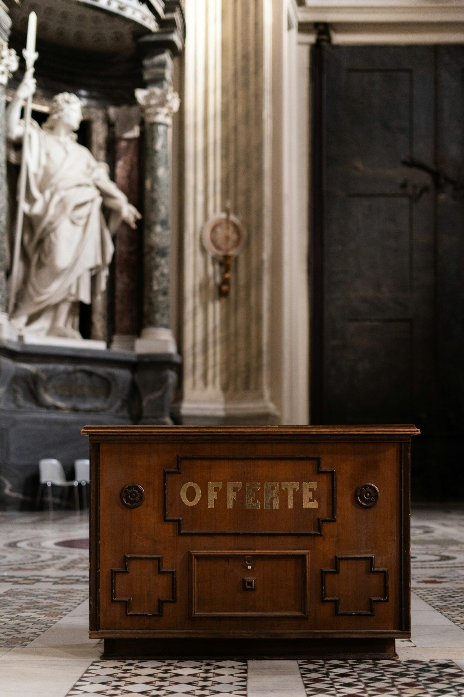 a wooden box sitting in front of a statue