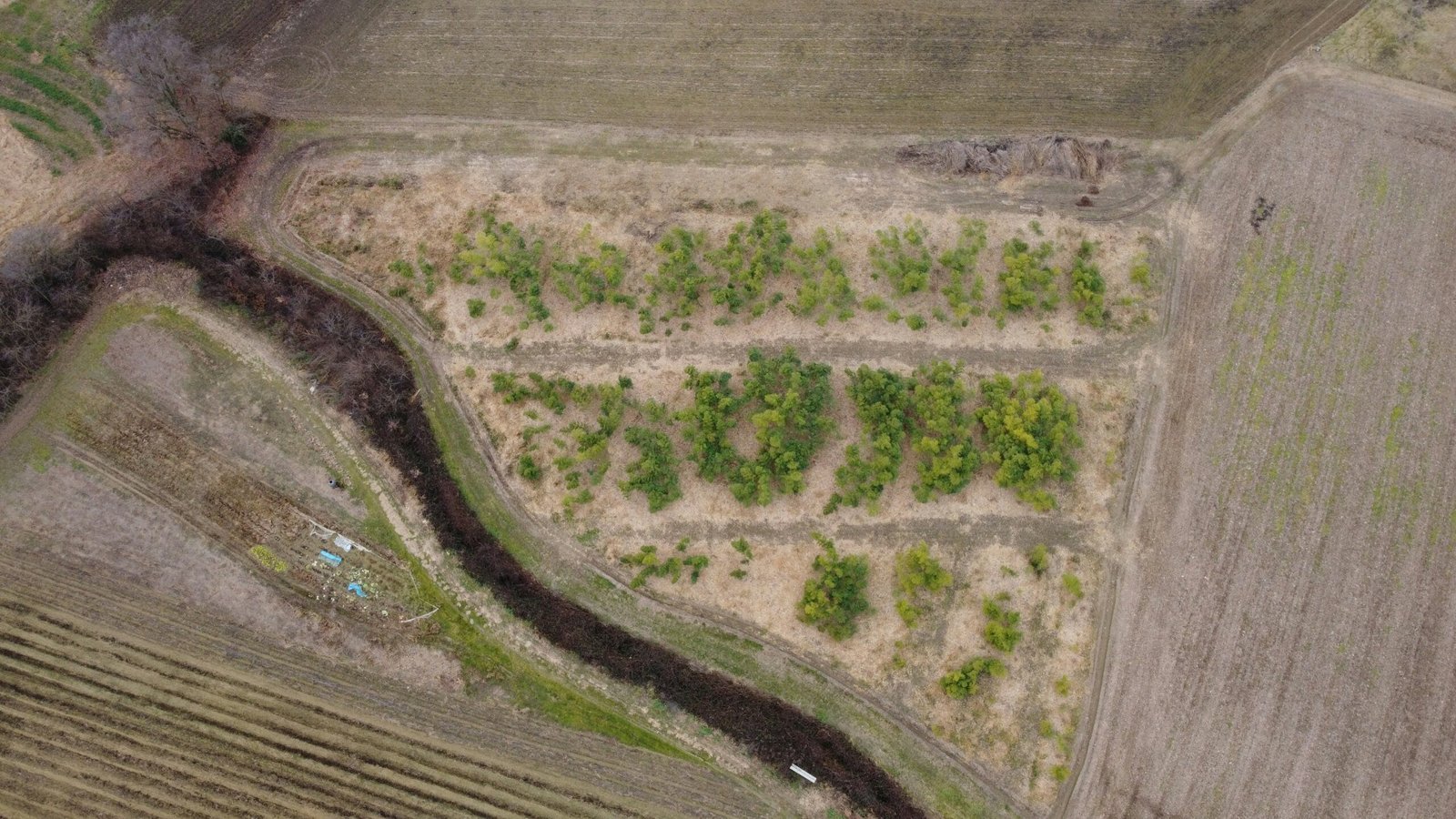 an aerial view of a field with a river running through it