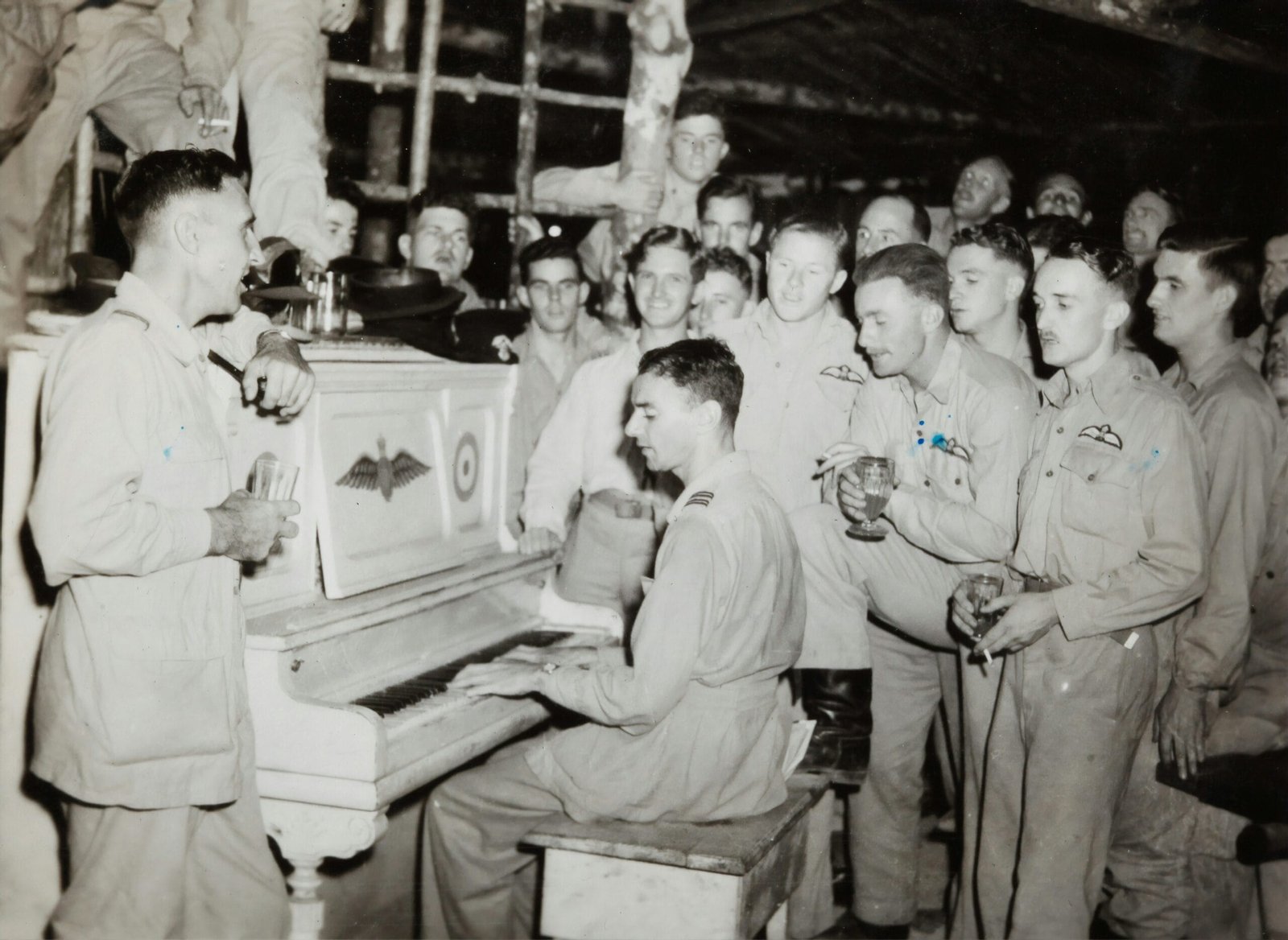 grayscale photo of 4 men standing beside piano