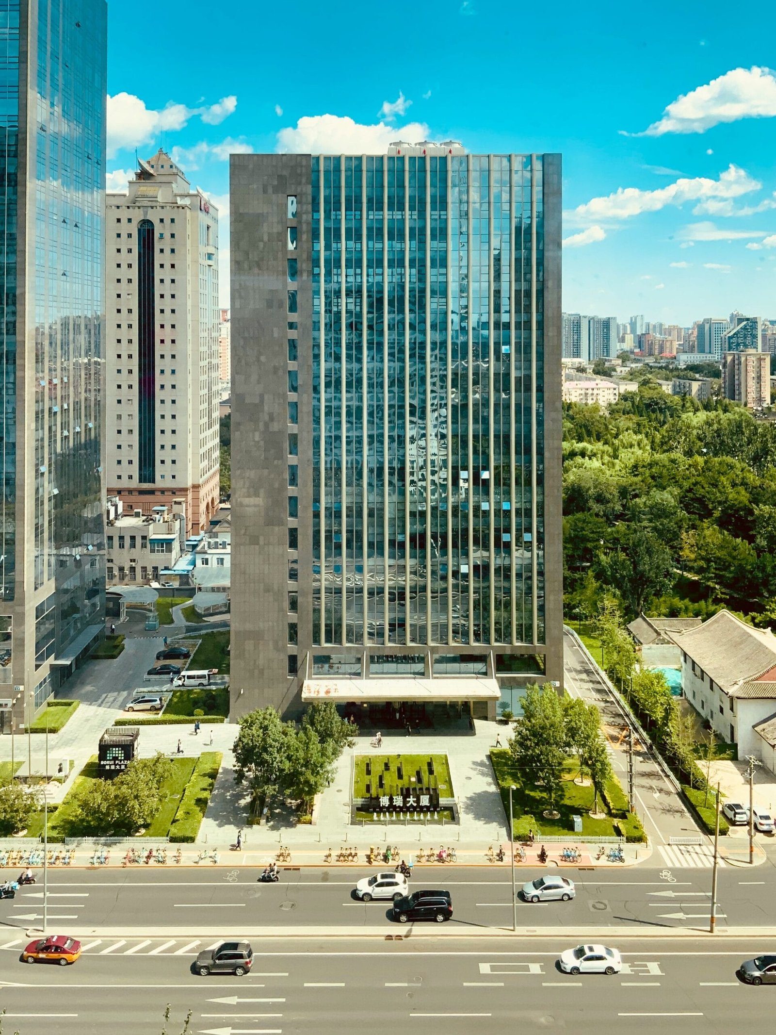 high rise building near green trees and road during daytime